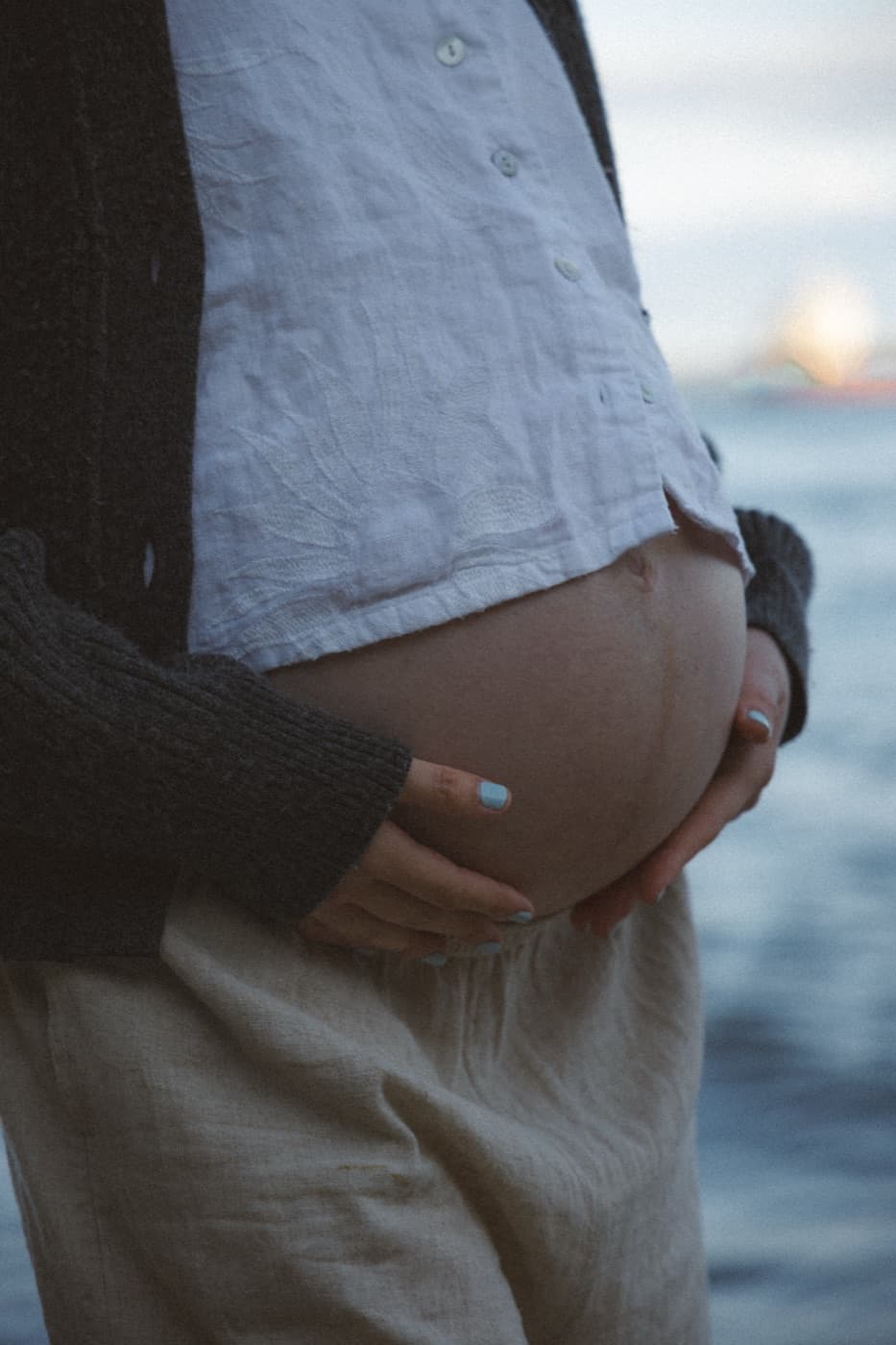 Hands supporting a pregnant belly