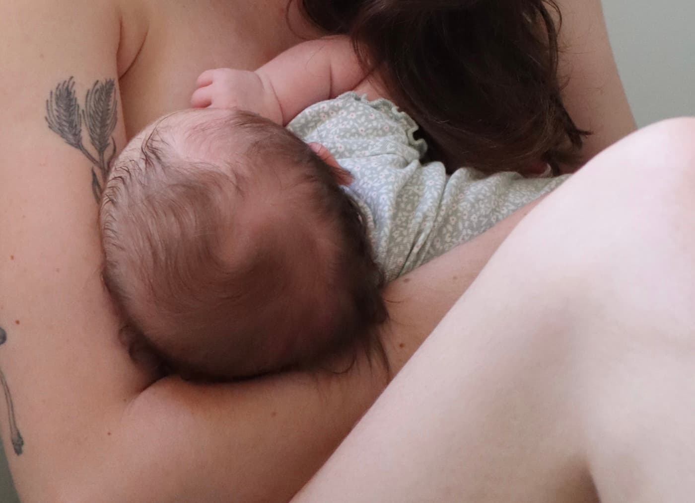 A parent holding a newborn close